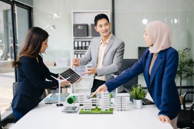 İş adamlarının şirket ofisinde rüzgar enerjisi hakkında görüşleri var. İş ekibi yel değirmenleri ve alternatif yeşil enerji hakkında konuşuyor. Ofiste yönetici toplantısı. 