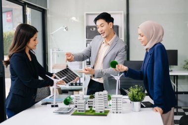 İş adamlarının şirket ofisinde rüzgar enerjisi hakkında görüşleri var. İş ekibi yel değirmenleri ve alternatif yeşil enerji hakkında konuşuyor. Ofiste yönetici toplantısı. 