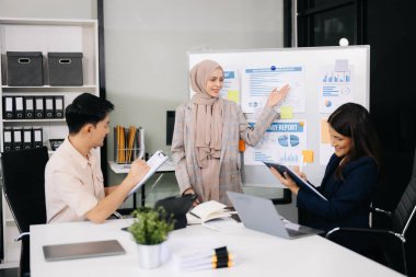 İş ortakları toplantıda belge ve fikirleri tartışıyor, yeni başlangıç projesiyle çalışıyorlar.