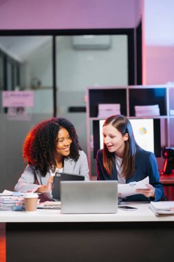 Kibar yönetici, iş çözümlerini paylaşıp tartışır ve modern ofiste, laptop, kahve ve tablet bilgisayarlı Afrikalı kadın pazarlama müdürüyle fikirler planlar.