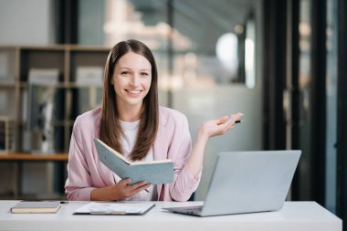 Modern Ofis 'teki dizüstü bilgisayarda ve defterde başarılı bir Kafkasyalı İş kadını Analiz Finansmanı 