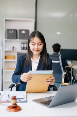 Güzel Asyalı kadın avukat ofiste belgelerle, danışmanlık ve hukuk konseptiyle çalışıyor. 