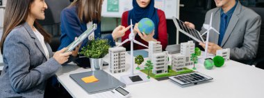 İş adamlarının şirket ofisinde rüzgar enerjisi hakkında görüşleri var. İş ekibi yel değirmenleri ve alternatif yeşil enerji hakkında konuşuyor. Ofiste yönetici toplantısı. 