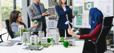 İş adamlarının şirket ofisinde rüzgar enerjisi hakkında görüşleri var. İş ekibi yel değirmenleri ve alternatif yeşil enerji hakkında konuşuyor. Ofiste yönetici toplantısı. 