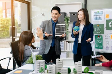 İş adamlarının şirket ofisinde rüzgar enerjisi hakkında görüşleri var. İş ekibi yel değirmenleri ve alternatif yeşil enerji hakkında konuşuyor. Ofiste yönetici toplantısı. 