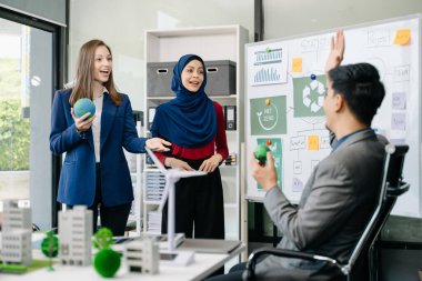 İş adamlarının şirket ofisinde rüzgar enerjisi hakkında görüşleri var. İş ekibi yel değirmenleri ve alternatif yeşil enerji hakkında konuşuyor. Ofiste yönetici toplantısı. 