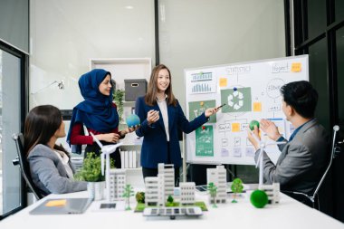 İş adamlarının şirket ofisinde rüzgar enerjisi hakkında görüşleri var. İş ekibi yel değirmenleri ve alternatif yeşil enerji hakkında konuşuyor. Ofiste yönetici toplantısı. 