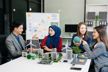 İş adamlarının şirket ofisinde rüzgar enerjisi hakkında görüşleri var. İş ekibi yel değirmenleri ve alternatif yeşil enerji hakkında konuşuyor. Ofiste yönetici toplantısı. 