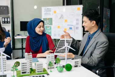 İş adamlarının şirket ofisinde rüzgar enerjisi hakkında görüşleri var. İş ekibi yel değirmenleri ve alternatif yeşil enerji hakkında konuşuyor. Ofiste yönetici toplantısı. 