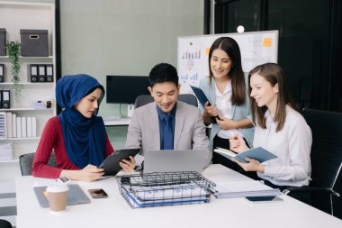 Çok ırklı genç yaratıcı insanlardan oluşan bir grup iş görüşmelerini tartışıyor fikir üreten tasarım projelerini ofisinde tartışıyor.