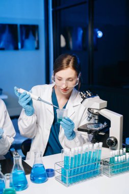 Modern tıbbi araştırma laboratuvarı. Biyokimyasal örnekleri analiz eden mikro pipetlerle çalışan kadın bilim adamları, tıp için ileri bilim kimya laboratuvarı.