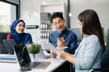 İş ortakları toplantıda belge ve fikirleri tartışıyor, yeni başlangıç projesiyle çalışıyorlar.