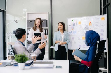 Çok ırklı genç yaratıcı insanlardan oluşan bir grup iş görüşmelerini tartışıyor fikir üreten tasarım projelerini ofisinde tartışıyor.