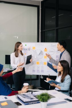 Çok ırklı genç yaratıcı insanlardan oluşan bir grup iş görüşmelerini tartışıyor fikir üreten tasarım projelerini ofisinde tartışıyor.