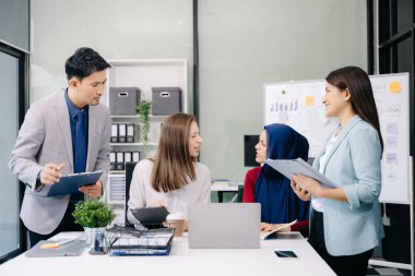 Çok ırklı genç yaratıcı insanlardan oluşan bir grup iş görüşmelerini tartışıyor fikir üreten tasarım projelerini ofisinde tartışıyor.