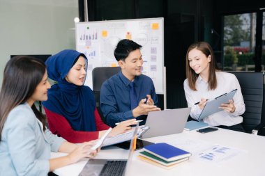 Çok ırklı genç yaratıcı insanlardan oluşan bir grup iş görüşmelerini tartışıyor fikir üreten tasarım projelerini ofisinde tartışıyor.