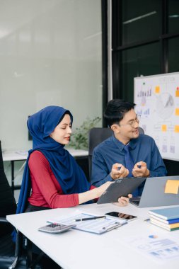 Ofiste yeni bir proje üzerinde çalışırken mutlu iş adamları. Ofiste bir dizüstü bilgisayar ve tablet kullanan bir grup iş adamı