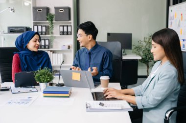 İş ortakları toplantıda belge ve fikirleri tartışıyor, yeni başlangıç projesiyle çalışıyorlar.