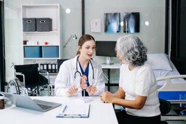 Kadın doktor ve hastasının portresi. Doktor hastane odasında hastaya tavsiye veriyor..