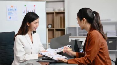 Modern ofiste birlikte çalışan başarılı iş kadınlarının portresi, dizüstü bilgisayar kullanarak 