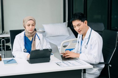 Doktorlar klinikteki hastanın sonuçlarını ya da teşhisini inceliyor. Hastanede dizüstü bilgisayar ve dijital tablet üzerinde tartışma ve araştırma yapan takım çalışması, tıbbi ve sağlık çalışanları