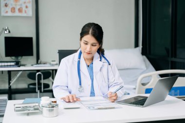 Ofis hastanesindeki masada oturan güzel doktor. İş için dizüstü bilgisayar kullanan çekici bir kadın terapist. 