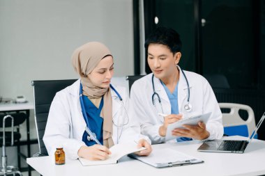 Doktorlar klinikteki hastanın sonuçlarını ya da teşhisini inceliyor. Hastane dizüstü bilgisayarında takım çalışması, tıbbi ve sağlık çalışanları tartışıldı ve araştırıldı