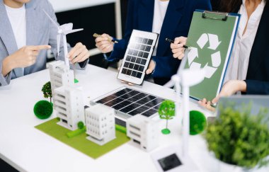 İş adamlarının şirket ofisinde rüzgar enerjisi hakkında görüşleri var. İş ekibi yel değirmenleri ve alternatif yeşil enerji hakkında konuşuyor. Ofiste yönetici toplantısı. 