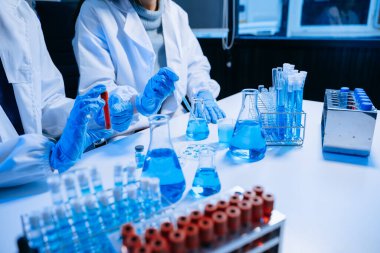 Kimya laboratuvarında kimyasal sıvıları karıştıran iki bilim adamı. Kimya laboratuvarında çalışan araştırmacılar ve yeni kimyasal maddeler