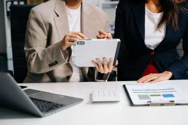 Ofisteki toplantıda dijital tablet ve dizüstü bilgisayar kullanarak mali durumu ve mali görevi analiz eden iş ekibi. Zenginlik yönetimi kavramı