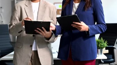 İki iş adamı ellerinde tabletle birbirlerine bir şeyler gösteriyorlar.