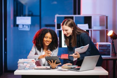 Nazik yönetici yönetici, modern ofisteki Afrikalı kadın pazarlama yöneticisiyle iş çözümlerini paylaşır ve tartışır..