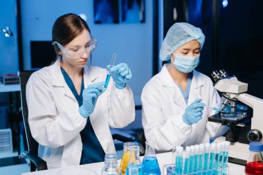 Laboratuvarda çalışan iki kadın bilim adamı. Tarım, araştırma konsepti ve test örnekleriyle bilim adamları.