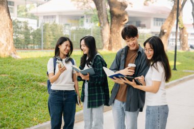 Üniversite öğrencileri sabahları kampüs parkında çalışıyor. Dijital tablet ve akıllı telefonla çalışıyorlar.
