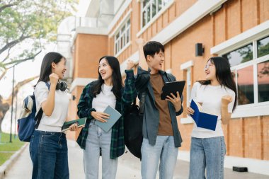 Üniversite öğrencileri sabahları kampüs parkında çalışıyor, dijital tabletlerle ve el hareketleriyle çalışıyorlar.  