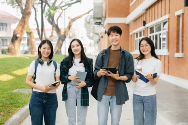 Üniversite öğrencileri sabahları kampüs parkında dijital tabletle çalışıyorlar. 