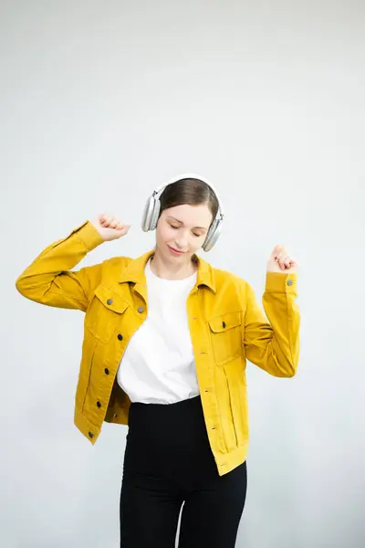 stock image  Young Caucasian woman 20s wears casual clothes dancing in headphones, spreading hands isolated on white background 