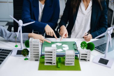 İş adamlarının şirket ofisinde rüzgar enerjisi hakkında görüşleri var. İş ekibi yel değirmenleri ve alternatif yeşil enerji hakkında konuşuyor. Ofiste yönetici toplantısı. 