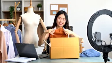Moda blogcusu konsepti, Asyalı genç bir kadının video yayınında kıyafet satışı. Akıllı telefon ve halka lambasını kullanarak küçük işletme KOBİ 'si başlat 