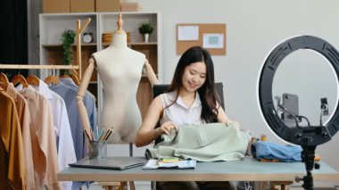 Moda blogcusu konsepti, Asyalı genç bir kadının video yayınında kıyafet satışı. Akıllı telefon ve halka lambasını kullanarak küçük işletme KOBİ 'si başlat 