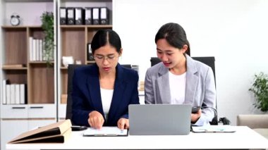 Modern ofiste birlikte çalışan başarılı iş kadınlarının portresi, dizüstü bilgisayar ve dijital tablet kullanarak 