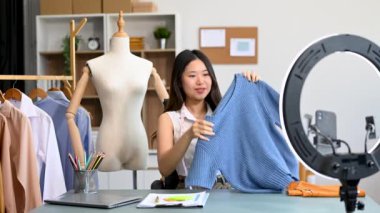 Moda blogcusu konsepti, Asyalı genç bir kadının video yayınında kıyafet satışı. Akıllı telefon ve halka lambasını kullanarak küçük işletme KOBİ 'si başlat 