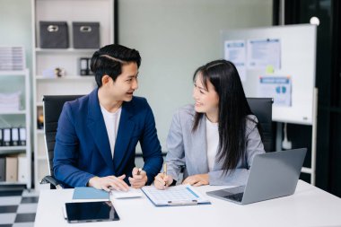 Nazik yönetici yönetici iş çözümlerini modern ofisteki dizüstü bilgisayarla paylaşır ve tartışır.