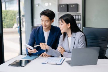 Nazik yönetici yönetici iş çözümlerini modern ofisteki dizüstü bilgisayarla paylaşır ve tartışır.