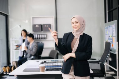 Kendine güvenen kadın girişimci ayakta kameraya bakıyor..