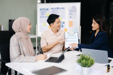 Başarı portresi. İş adamları modern ofiste birlikte çalışıyorlar. Çalışma sürecini tartışıyorlar. 