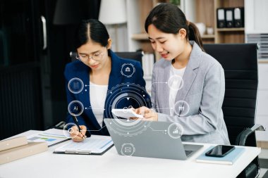 Ofiste dizüstü bilgisayar kullanan iki Asyalı iş kadınının iş grafiği 