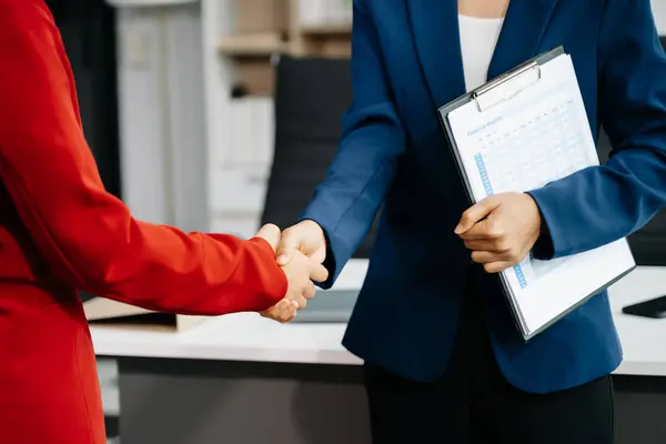 stock image Two business women at the office shacking hands 