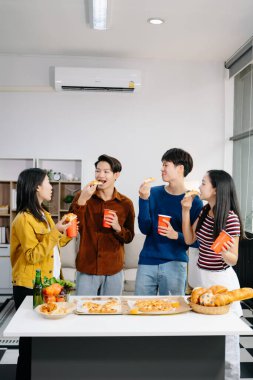 Bir grup Asyalı genç arkadaş evde akşam partisinin tadını çıkarıyorlar. Çekici genç erkek ve kadınlar eğleniyor, yemek yiyor ve içkiden zevk alıyor, modern evde kutlama yapıyorlar.