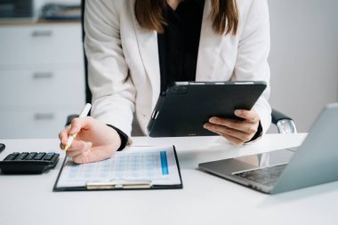 İş kadını elleri ofiste dijital tablet bilgisayar ve dizüstü bilgisayarla çalışıyor.